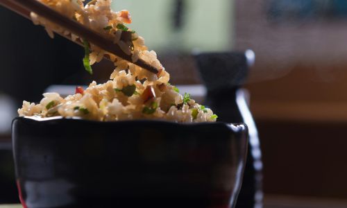 cup of fried rice with chopsticks
