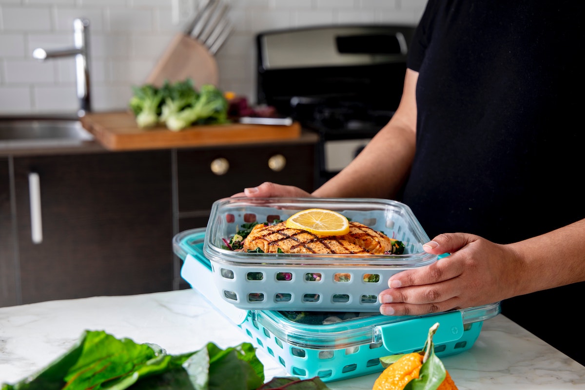 person with meal in tupperware to store in freezer