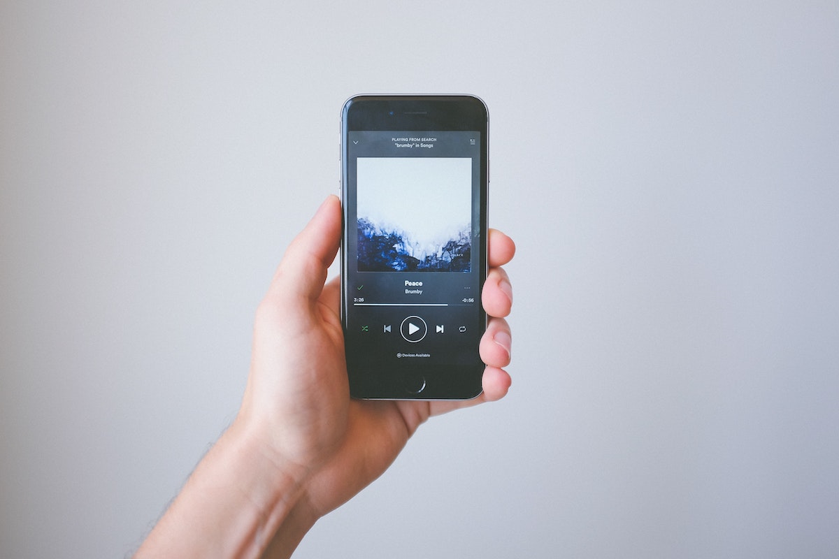 Music Streaming Services person holding phone with streaming site like spotify