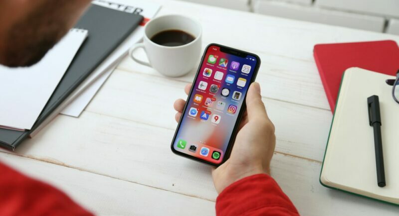 Person holding iphone looking at their apps