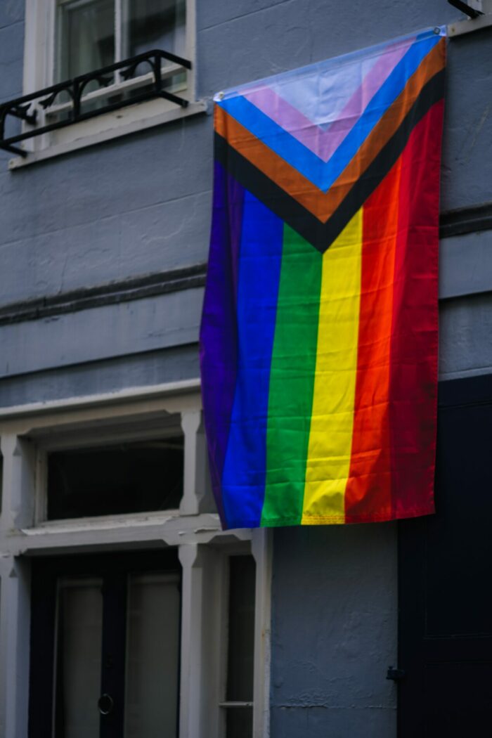 Progress pride flag hanging from window