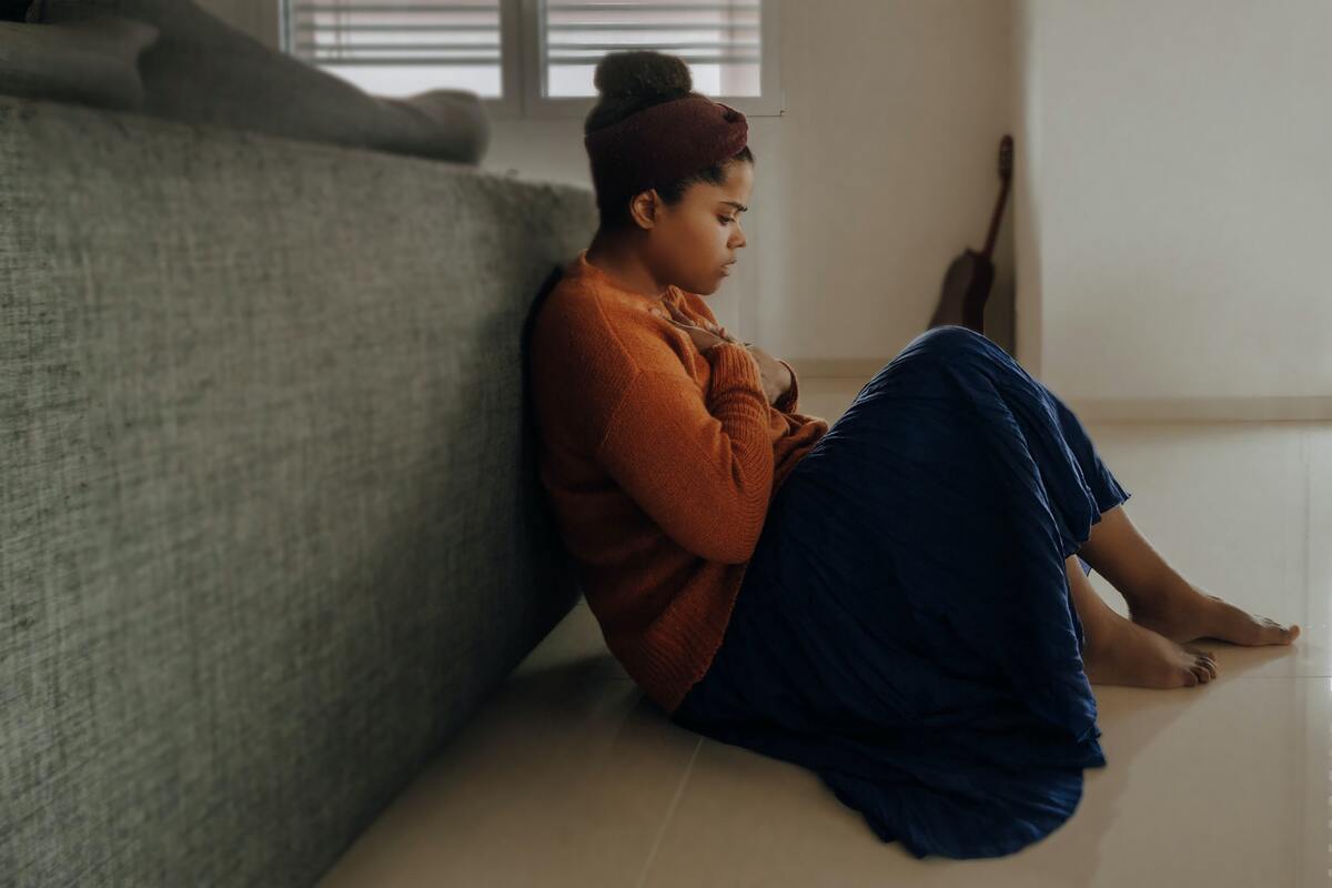 girl sat on the floor looking worried