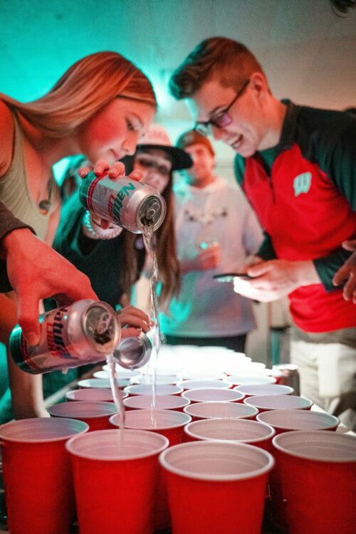 People pouring beer - beer pong - avoid drink spiking