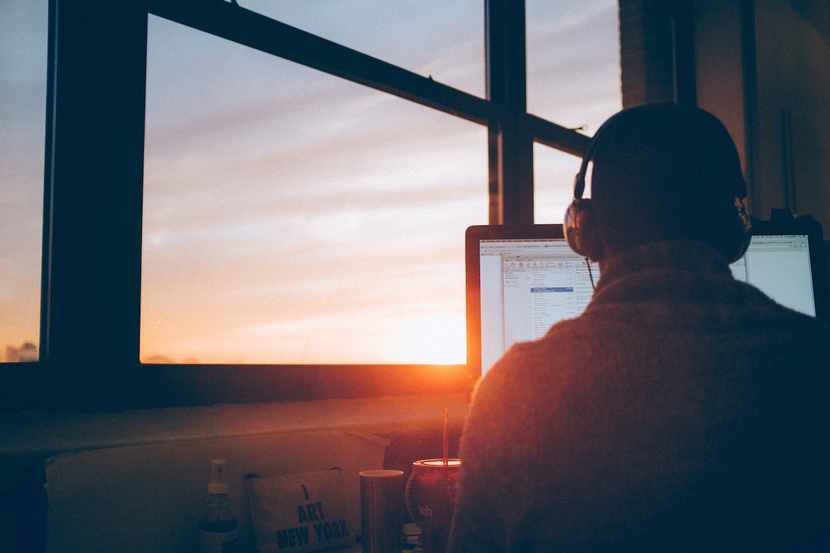 person with headphones on laptop