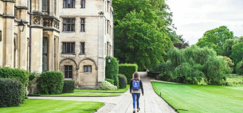 Student walking down a path towards her university