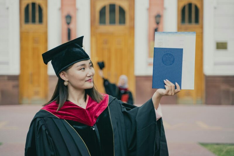 Woman in graduation cap holding up her diploma