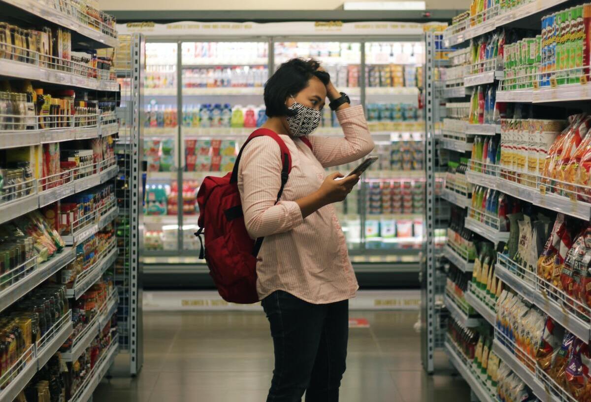 woman in supermarket looking concerned